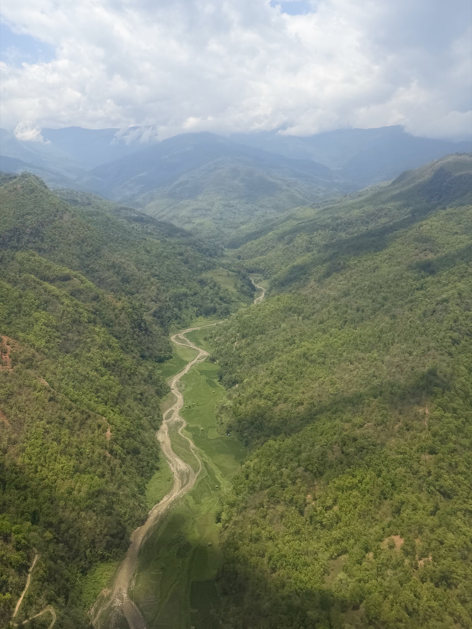 A green valley floor in the Himalayan foothills